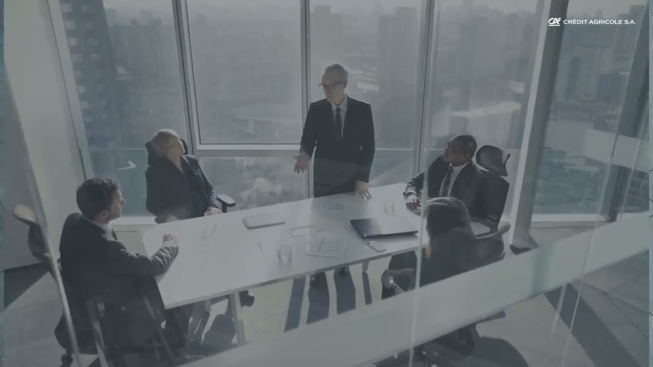 une réunion de cinq personnes autour d'une table avec un homme debout